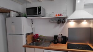 Cocina compacta con microondas, cafetera y lavavajillas.