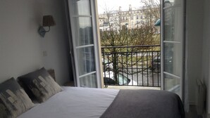 Une chambre à coucher avec un lit, une fenêtre et une vue sur la rue.