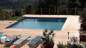 A rectangular swimming pool with a wooden deck, surrounded by lounge chairs and potted plants. - Country cottage with swimming pool in the Quercy Regional Park (Larnagol)