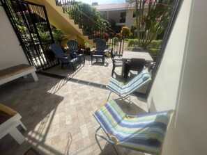 A patio area with a bench, chairs, and a table. - Newly Remodeled Condo MS #1 With 200MB Internet (Coco)