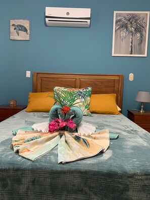 A neatly made bed with a tropical-themed pillow and a decorative centerpiece. - Newly Remodeled Condo MS #1 With 200MB Internet (Coco)
