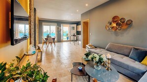 Una sala moderna con un sofá, una mesa de centro y un comedor con sillas.