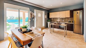 Una cocina moderna con comedor, ventanas amplias y vistas al exterior.