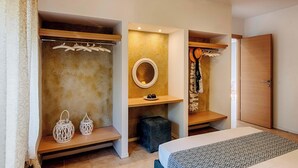 Un dormitorio con cama, armario, espejo y repisas con objetos colgando.
