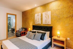 Une chambre à coucher avec un lit, des tables de chevet, une chaise et des œuvres d’art accrochées au mur.