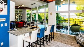 A modern kitchen with a granite countertop, white bar stools, and a dining area with a glass partition. - Lg House w beautiful River View 2 stories, 5bd3bth (Kennewick)