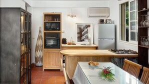 A compact kitchen with a wooden countertop, a built-in microwave, a gas stove, and a refrigerator. - Domaine de Néron - Daïquiri (Le Moule)