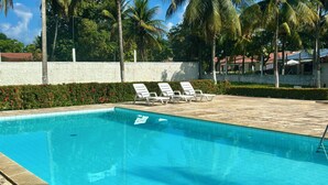 A clear blue pool with white lounge chairs and a white wall in the background. - Beach house in São José da Coroa Grande, with Wi-Fi and TV. (São José da Coroa Grande)