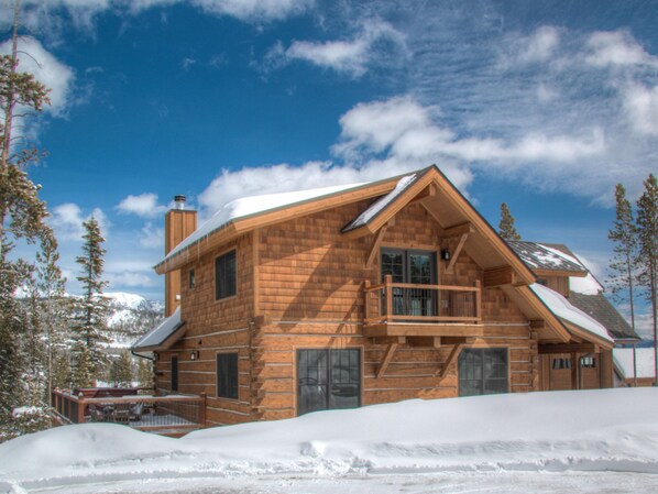 A log cabin with a balcony, surrounded by snow and trees. - Big Sky Vacation Rentals: PR Manitou 5 (Gallatin Gateway)
