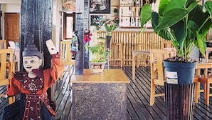 Eine Holzterrasse mit einer Bank, einem Blumentopf und einer Dekofigur.