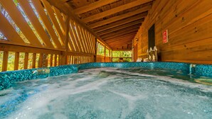 A wooden spa with a hot tub surrounded by a turquoise mosaic border. - SugarShack: Private, Wooded, Honeymoon, Hot Tub, Game Room, Wifi, near Dollywood (Sevierville)