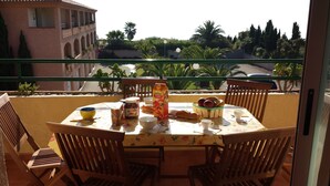 A balcony with a table set for breakfast, including bread, fruit, and condiments. - Marina di Bravone beach, Linguizzetta, Corsica, France (Linguizzetta)