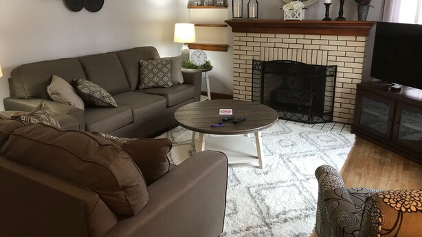 Una sala de estar con sofá, mesa de centro y chimenea.