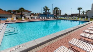 A swimming pool with lounge chairs and a no diving sign.