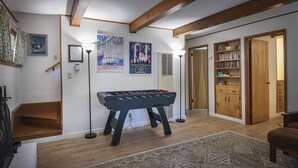 A cozy room with a foosball table, wooden bookshelves, and a staircase. - (19B) Yosemite Retreat in the Meadows at The Redwoods In Yosemite (Wawona)