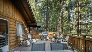 A wooden deck with outdoor furniture, a grill, and a view of the forest. - (19B) Yosemite Retreat in the Meadows at The Redwoods In Yosemite (Wawona)