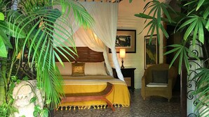 A bedroom with a bed, a chair, and a nightstand. - Romantic Zone, best location; with daily maid and cook service included! (Puerto Vallarta)