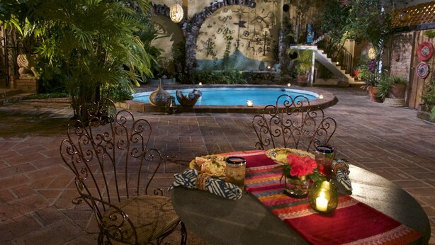 An outdoor patio with a pool, surrounded by plants and a decorative wall. - Romantic Zone, best location; with daily maid and cook service included! (Puerto Vallarta)
