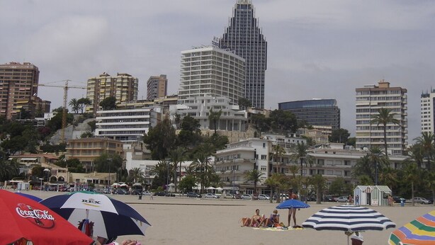 A beach with umbrellas and a cityscape in the background. - BALI-BENIDORM HOTEL FRONT APARTMENT (Finestrat)