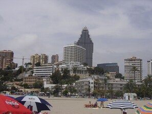 A beach with umbrellas and a cityscape in the background. - BALI-BENIDORM HOTEL FRONT APARTMENT (Finestrat)