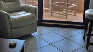 A balcony with two chairs, a table, and a view of the ocean. - Sunset Jetty View! Enjoy one free beach chair set up and umbrella each day! (Destin)