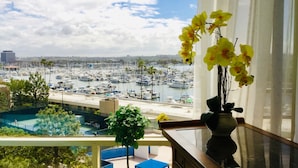 Ein Balkon mit Blick auf einen Yachthafen, ein Schwimmbecken und eine Stadtlandschaft.