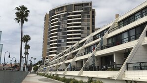 Ein modernes Gebäude mit einer geschwungenen Fassade und mehreren Balkonen.