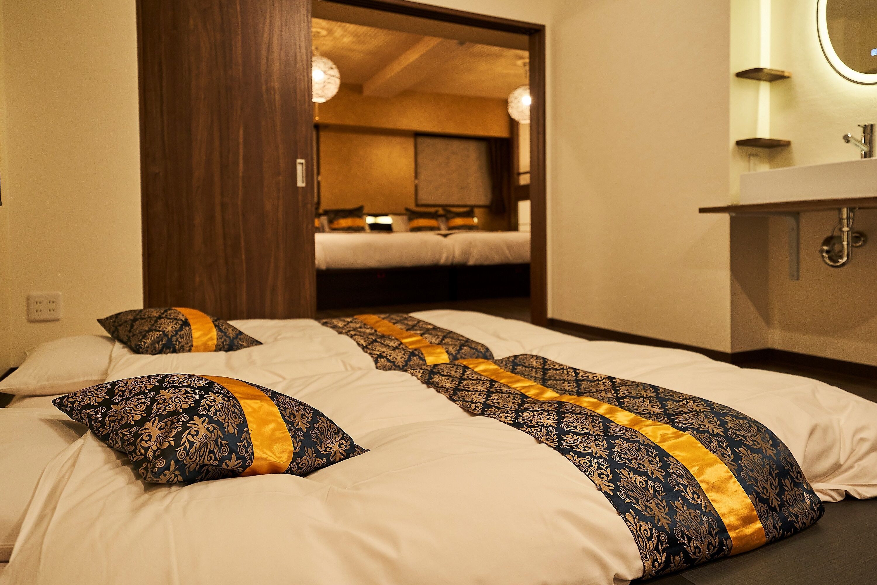 Une chambre d’hôtel avec un grand lit, une porte en bois et une salle de bain équipée d’un miroir et d’un lavabo.