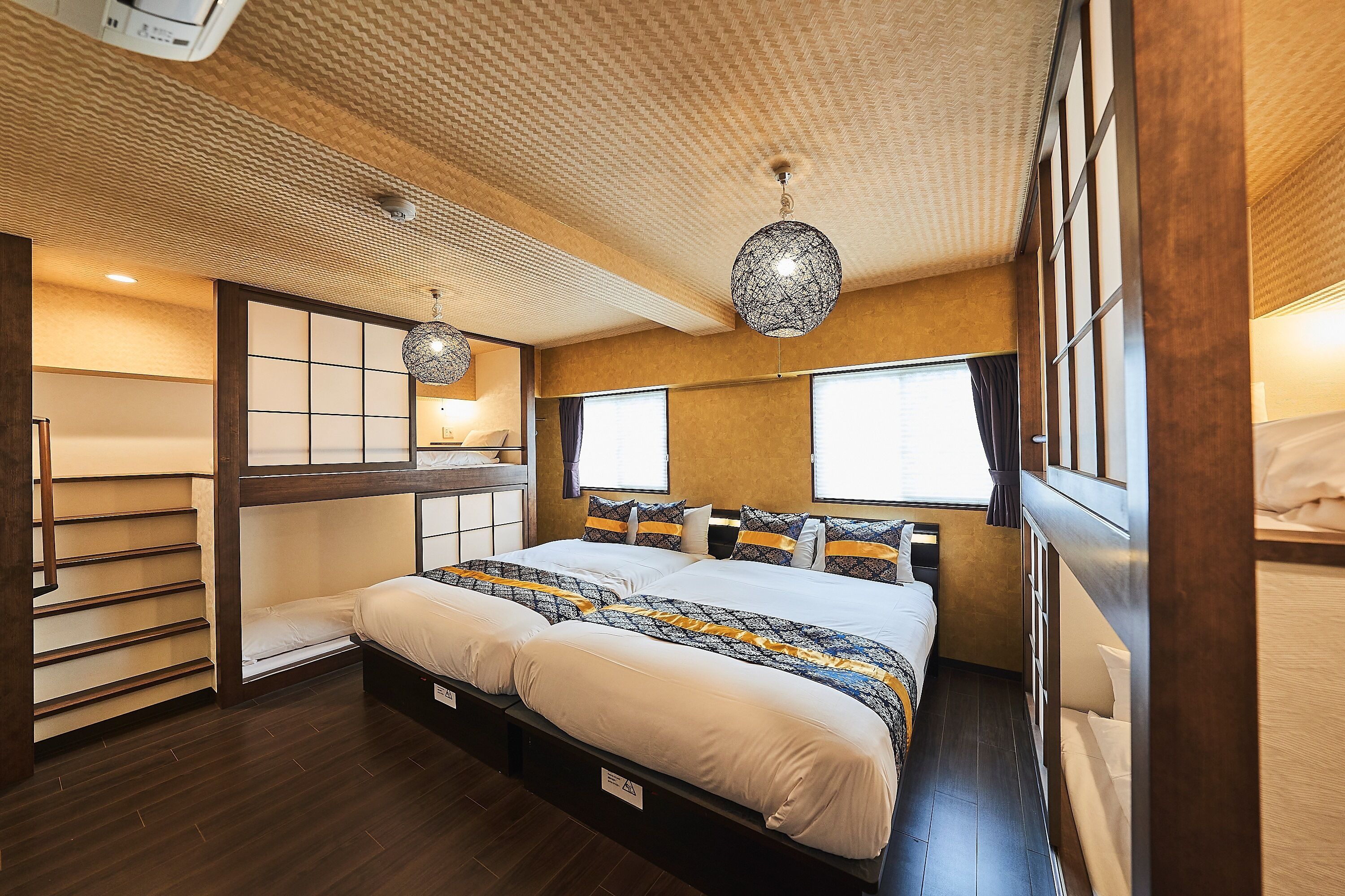 Une chambre dotée d’un grand lit, d’une tête de lit en bois et d’un plafond orné d’un motif texturé.