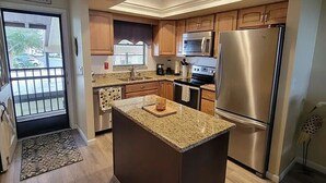 Uma cozinha moderna com bancadas de granito, eletrodomésticos de aço inoxidável e armários de madeira.