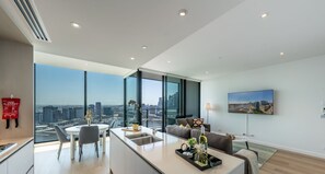 Apartamento moderno com cozinha, sala de jantar e sala de estar, com amplas janelas e vista para a cidade.
