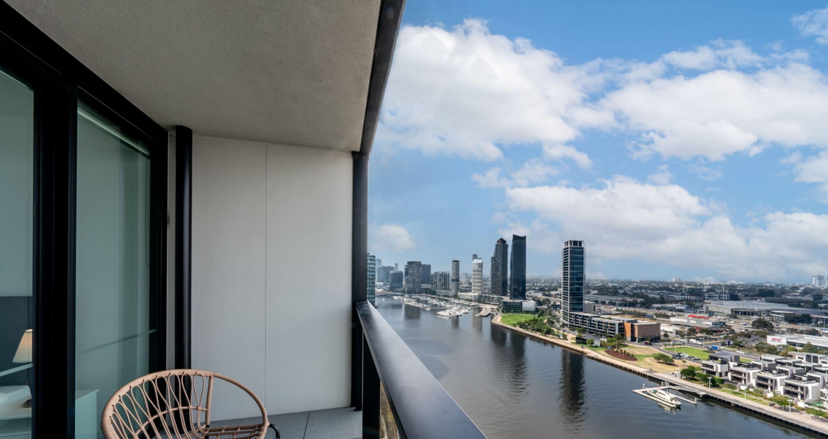 A balcony with a view of a city skyline and a river.