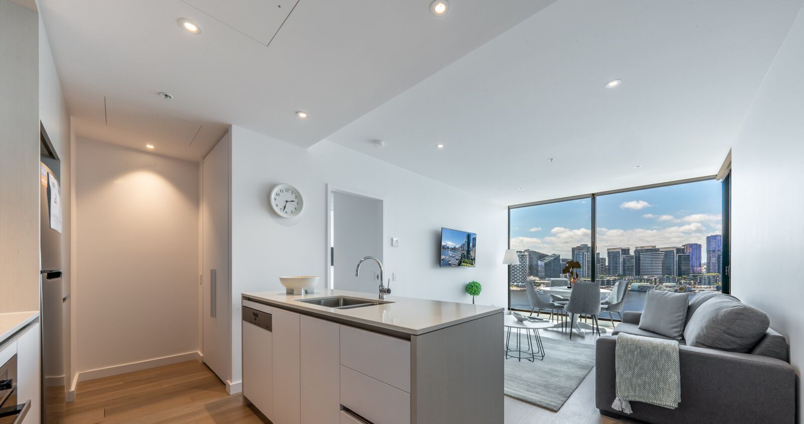 Un apartamento moderno con cocina, comedor y un amplio ventanal con vista a la ciudad.
