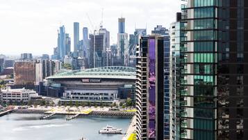 A waterfront view of a city with modern buildings, including a stadium and high-rise structures.