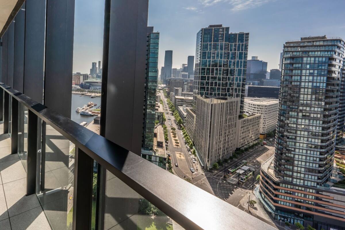 Een modern gebouw met een glazen gevel en uitzicht op de stadsachtergrond.