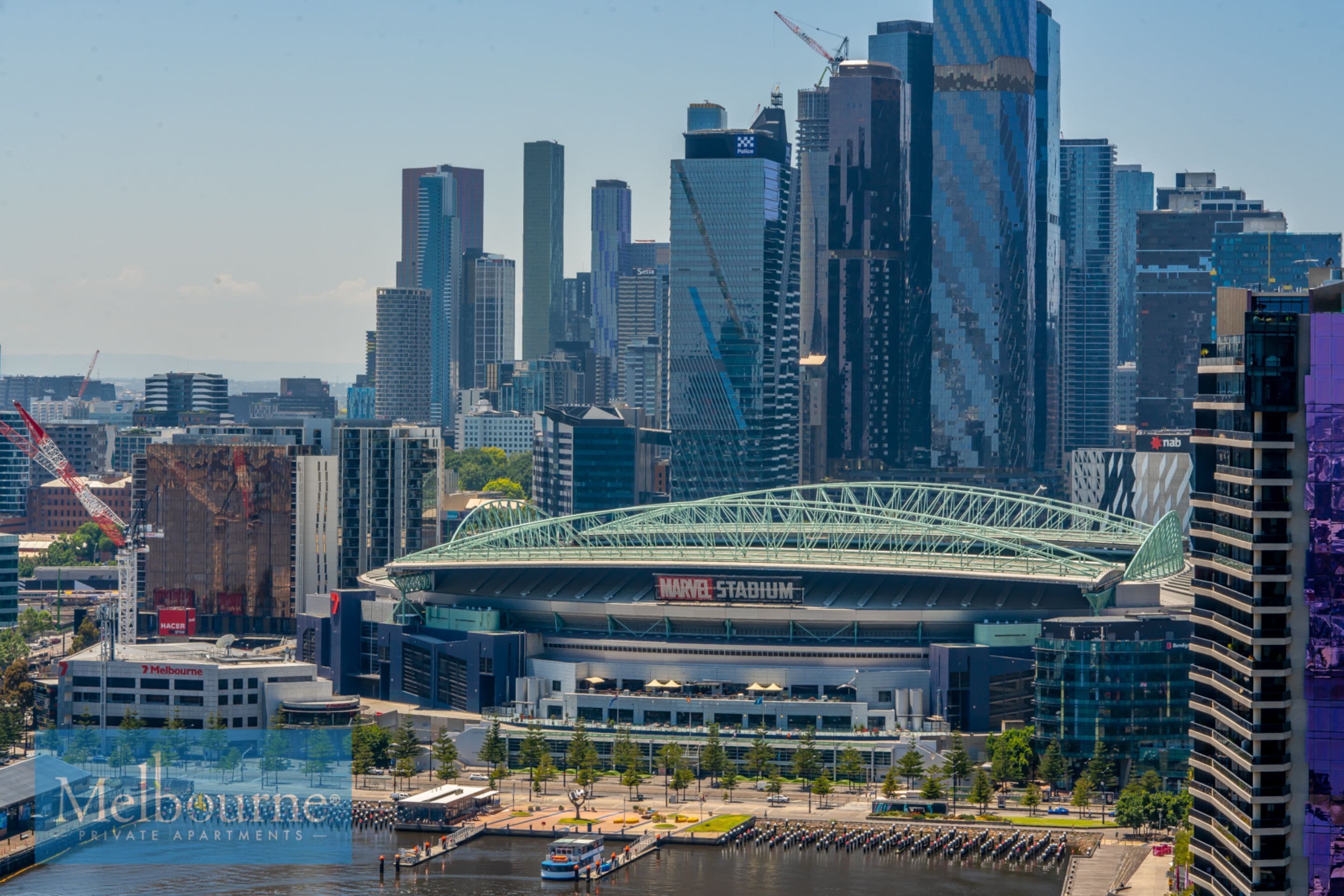 Une vue urbaine avec un stade imposant et de nombreux immeubles de grande hauteur.