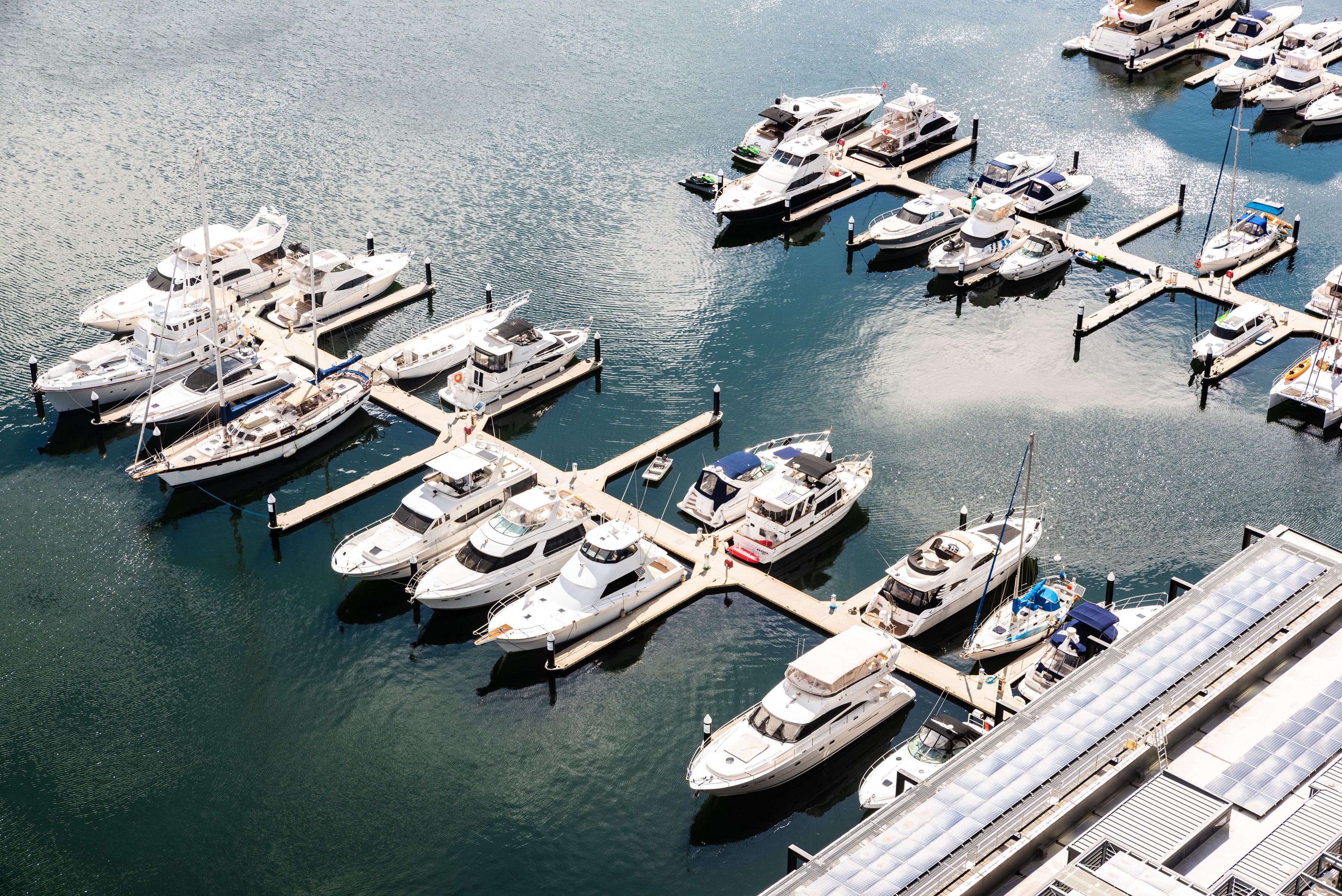 A marina with multiple yachts docked at piers.