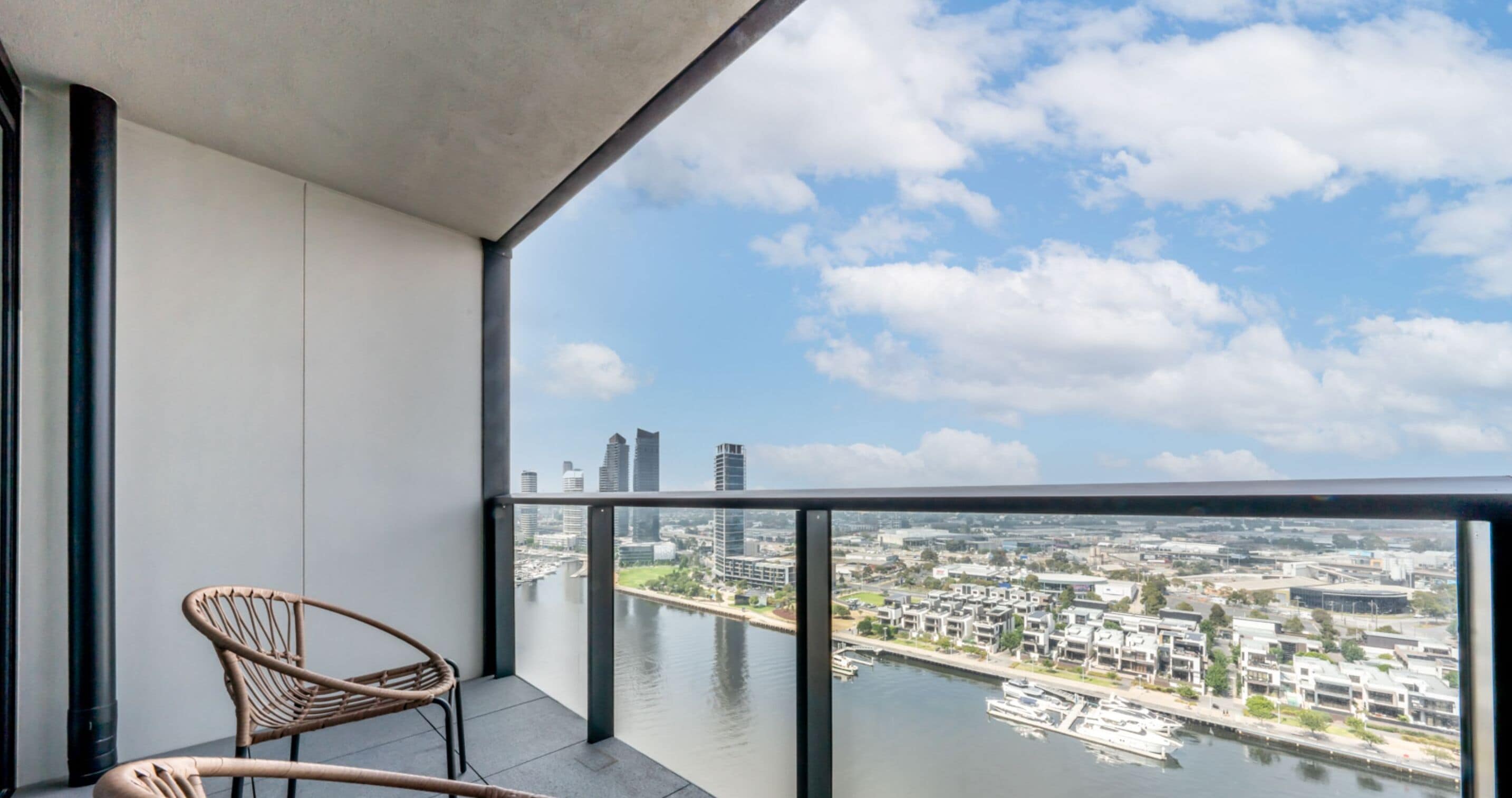 A balcony with a view of a cityscape and a river.