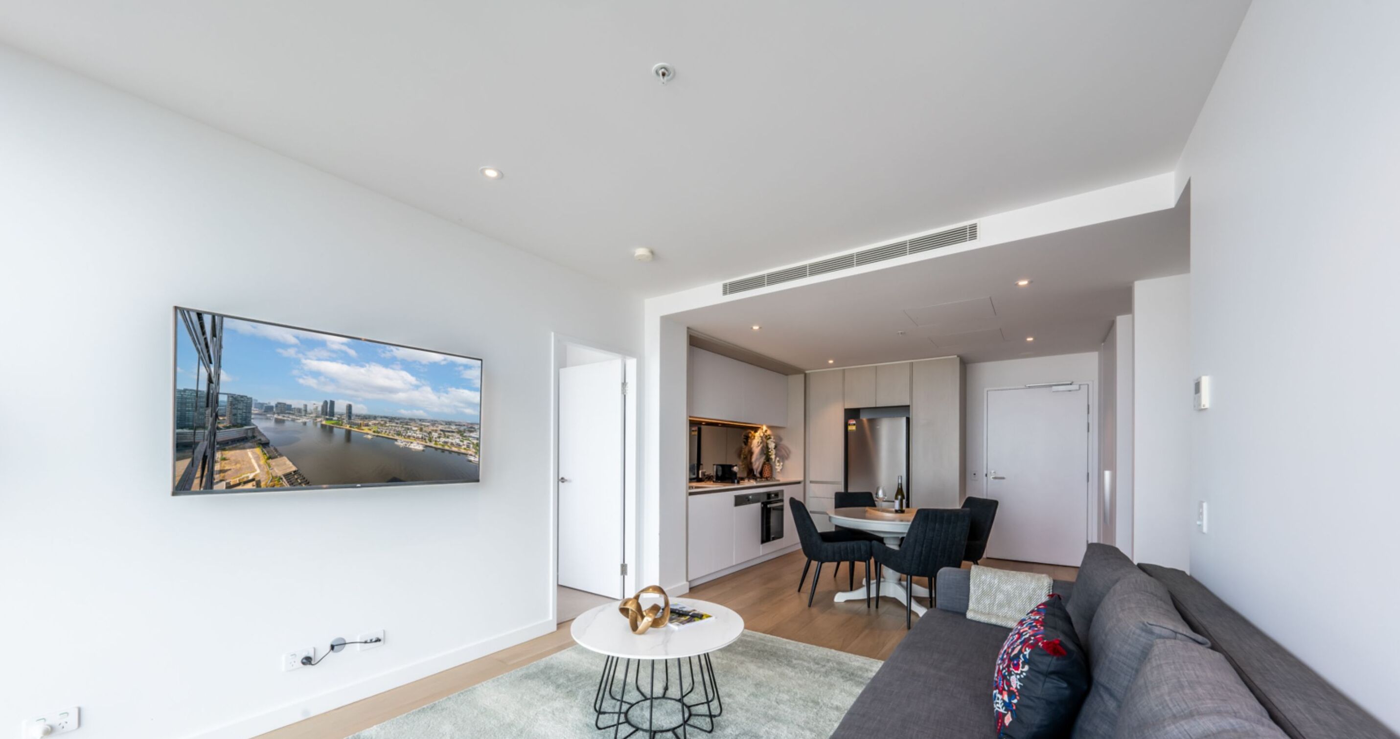 A modern apartment with a dining area, kitchen, and living room.
