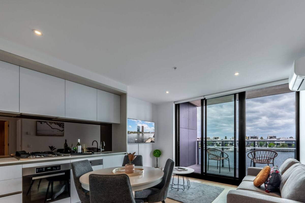 Een modern appartement met keuken, eethoek en balkon met uitzicht op de stad.