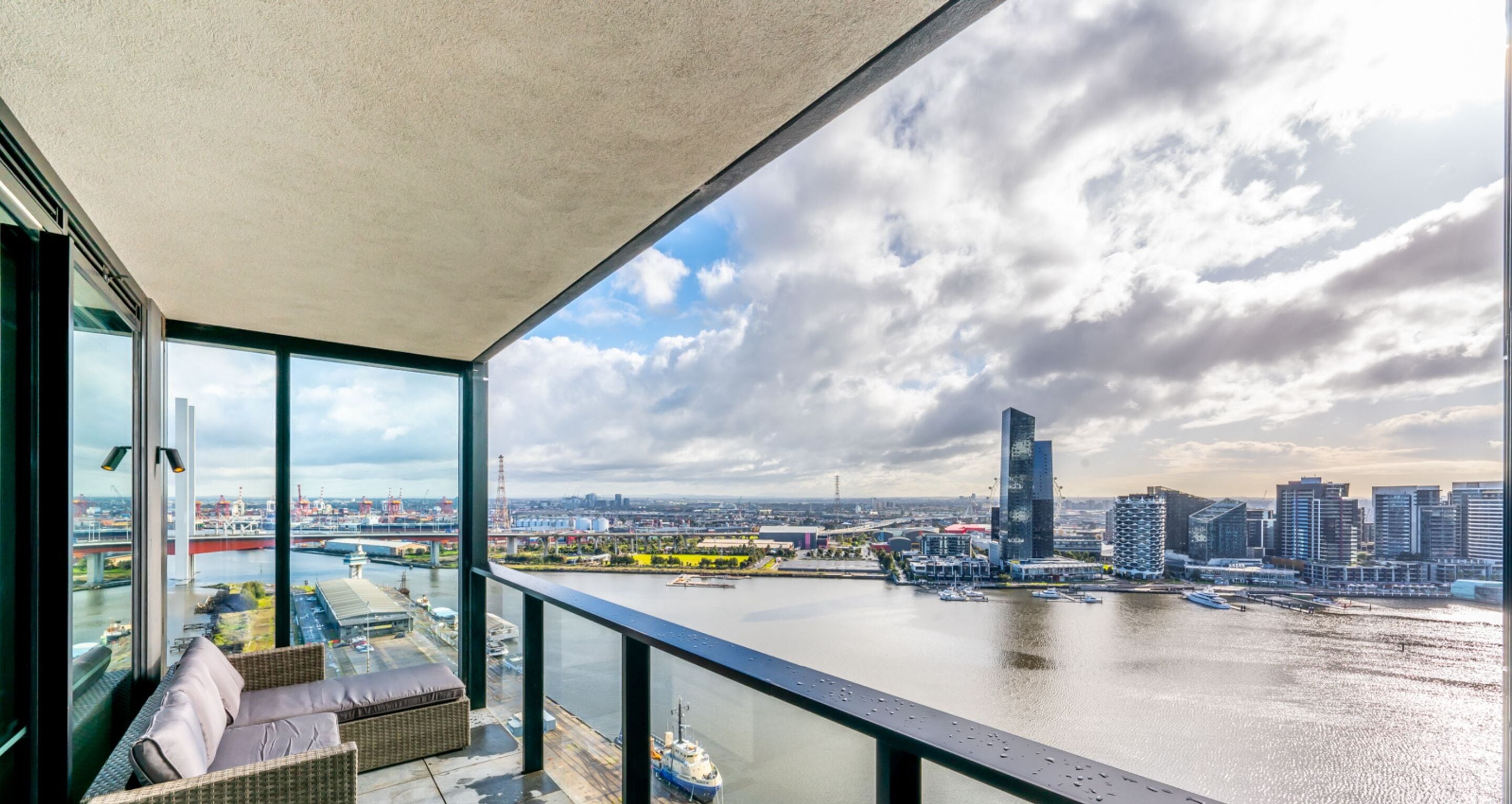 Ein Balkon mit Blick auf einen Fluss und die Stadtlandschaft, einschließlich einer Brücke und moderner Gebäude.