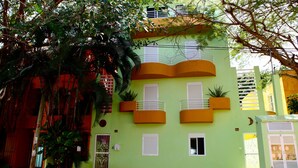 Edifici de dues plantes amb balcons, una porta amb reixat decoratiu i la frase "VIVA MARIA" a la planta baixa.