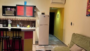 Un espai vital compacte amb cuina americana, zona de menjador i zona d'estar.