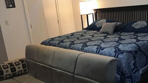 A bedroom with a bed, a sofa, and a nightstand. - King Master Suite Studio (McAllen)