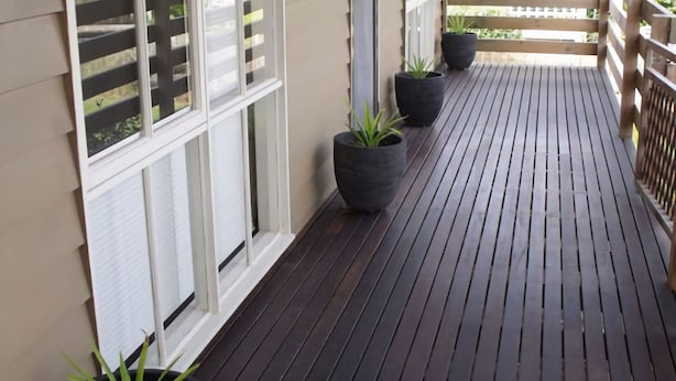 A wooden deck with potted plants and a white railing. - Emada Venus Bay - a stone's throw from cafes and shops inVenus Bay (Venus Bay)