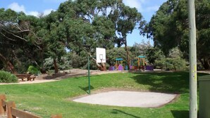 A park with a basketball court, picnic tables, and playground equipment. - Emada Venus Bay - a stone's throw from cafes and shops inVenus Bay (Venus Bay)