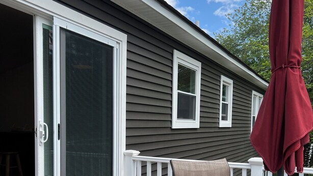 A patio with a glass table, chairs, and a red umbrella. -  Great 5 Bedroom in Beautiful Bonnet Shores, Narragansett R (Narragansett)