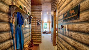 Ein Holzblockhaus-Innenraum mit einem Flur, der in einen Wohnbereich führt.
