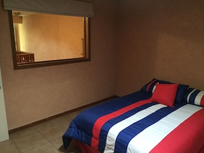Un dormitorio con cama, ventana y puerta.