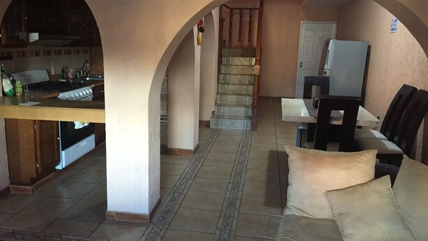 A spacious living area with a kitchen, a dining table, and a sofa. - 4 Recamaras Zona Sur WiFi Jardin Cochera (Zapopan)